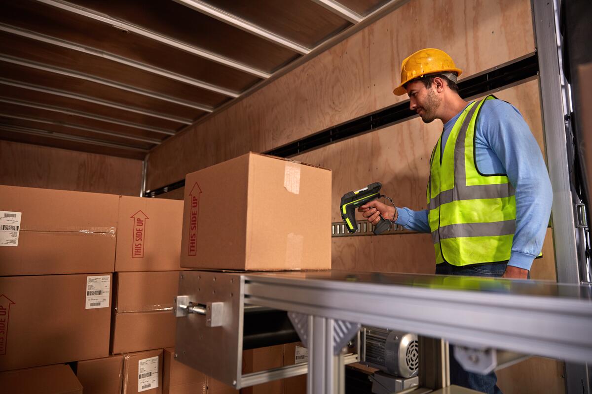 Warehouse worker using an RFID scanner on packages.