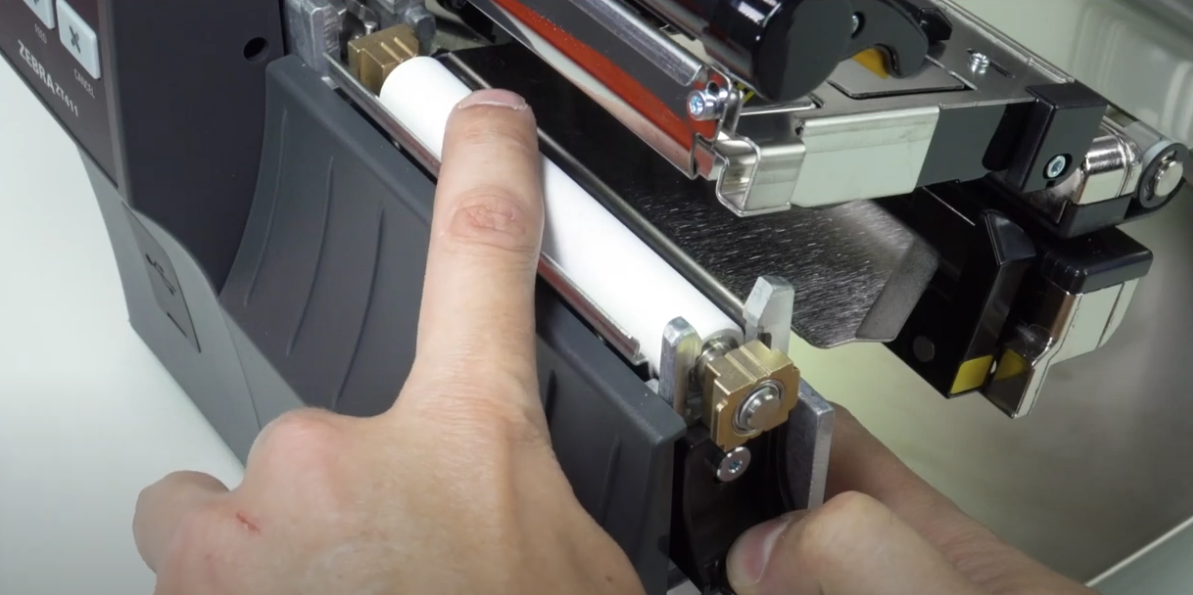 Shows a repair person removing the old platen roller in a Zebra ZT400 Series Printer